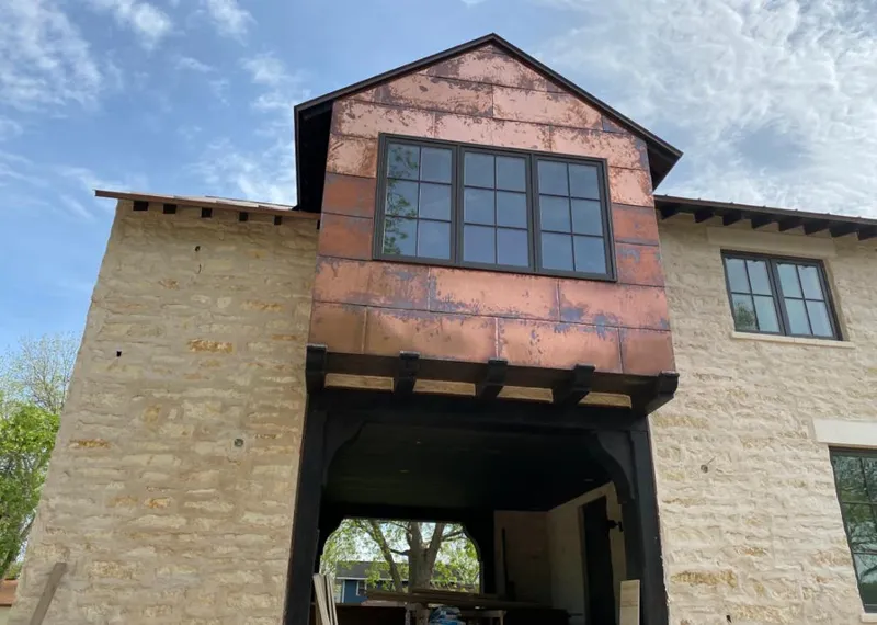 Copper metal panel facade on a stone building for Skylight Installation in Lake Holiday
